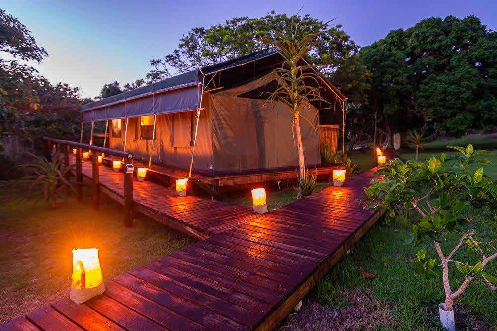 Candlelit walkway to luxury safari tent at Kingfisher Lakeside Retreat – Joxilox review