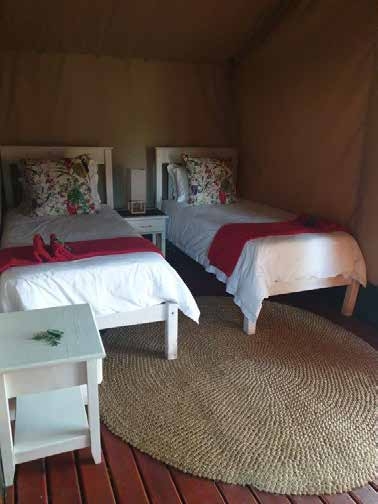 Wooden deck lounge area at Kingfisher Lakeside Retreat safari tent